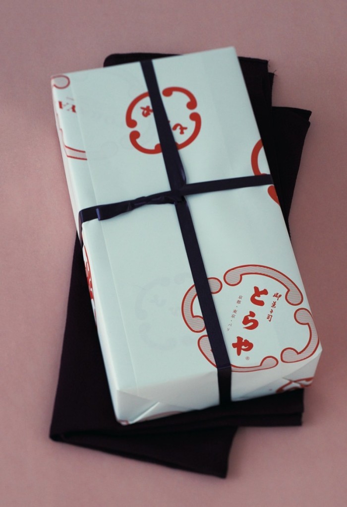 贈答品の包みの例。「鐶虎」デザインの包装紙を、紫色の紐で松葉結びしたもの。用途に応じて短冊、掛紙、水引も用意している。