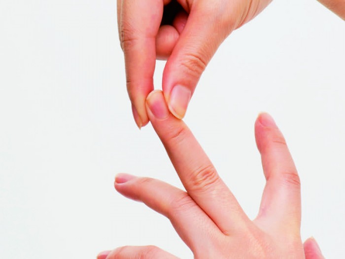 中指の先を反対の手の親指と人差し指でつまみ、指の根元から大きく左右に20回ずつ回す。