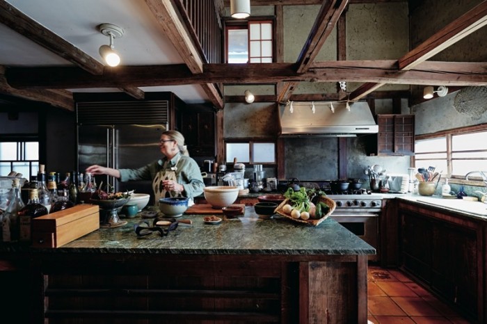 開放的で広々としたキッチン。水屋箪笥の上に天然石の天板を敷いた見事な作業台を台所の中央に配置。