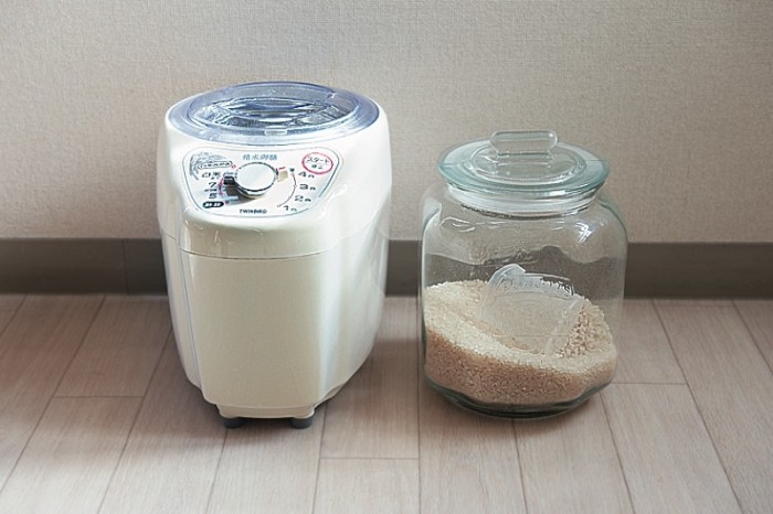週間分の玄米を左の精米機にかけて、精製した米をガラスの保存瓶に入れておく。