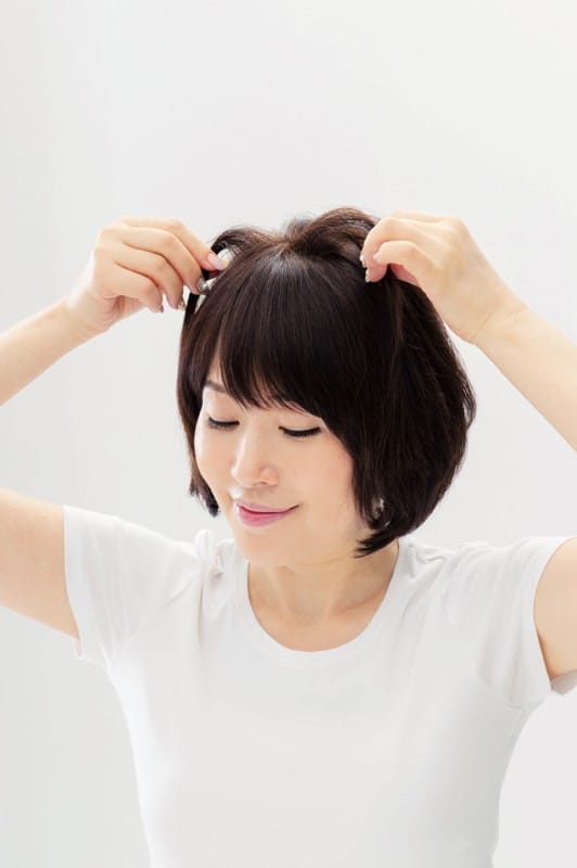 1.頭頂部の髪を指でつまんで持ち上げて空気を入れ、ふんわりとした立体感を作る。