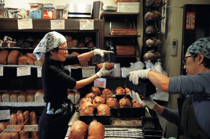 開店ギリギリまで次々と焼きあがるパンを、手際よく棚へ納める。