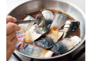 魚を煮るときは、身を下にするのがコツ。煮汁をかけ、皮の表面を固める。