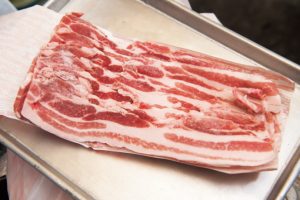 1. 近所の精肉店から仕入れる豚の三枚肉。長さ10cm程度に切り、塩コショウをする。