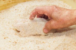 2. 小麦粉を水に溶いた衣液にくぐらせ、自家製のパン粉を押し付けるようにつける。