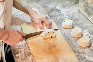 3.包丁で均等に切り分けて、少しねかせてから窯へ。