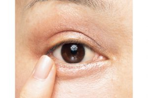 2. 目の下の際、目頭から目尻にかけて、1と同じ色を薬指で約3mm幅にいれる。ふっくらした涙袋を作るようなイメージで。肌になじむコーラルピンクが目元に自然な奥行き感を生む。