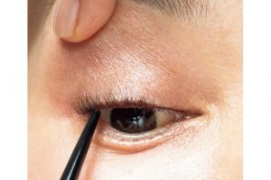 3. ビューラーでまつ毛をカールさせた後、目の際が見えるよう、まぶたを持ち上げ、まつ毛の内側にダークブラウンのアイライナーでインサイドラインを描く。仕上げにマスカラを塗る。
