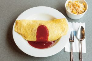 スプーンを入れると卵がとろり。食欲をそそるオムライスは900円（税込）。食事メニューにはキャベツとコーンのコールスローサラダがつく。