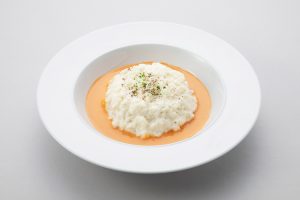 『ホワイトオムライスのビスクソース仕立て』（1,200円）黄身まで白い卵“ピュアホワイト”を使ったホワイトオムライス。オマール海老のうま味がつまったビスクソースとの色のコントラストもポイント。