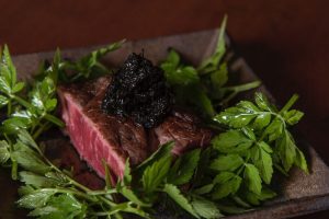 博多和牛に希少な有明海柳川産のお刺身海苔をトッピングした肉のプレート。沿線地域の農産物から水産物まで幅広い食材を使い、沿線地域の食材の豊かさを堪能できる。