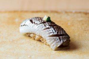 『鮨 まるふく』の熟成鮨。濃厚な旨味のネタと、赤酢のシャリが調和した、至福の味わい。鰯（熟成20日）。