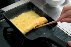 卵焼きは前の晩に作り置き。牡蠣醤油とみりんで調味した卵をきれいに焼き、最後にクッキングペーパーで全体を包みなじませる。