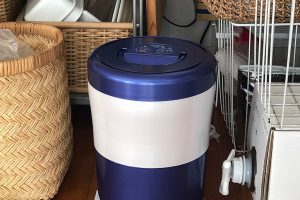 島産業の生ごみ減量乾燥機「パリパリキューブブライトアルファ」。メーカー小売希望価格2万7600円。高さ約28cm、左隣のゴミ箱と同じくらいの大きさ。