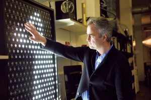 自身のスタジオ内で。人などの動きに合わせ、シルエットが映し出されるパネルに手をかざすブルージュさん。