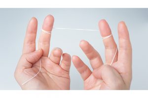 まず40〜50cmの長さにカットしたフロスを左右の中指に巻き付ける。