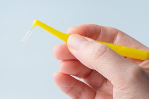 短く持ち、頬の側からブラシを挿入する。