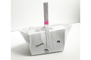 真っ白な紙袋に山本さんの顔と愛猫がモチーフのスタンプを押して、自分らしくラッピングするのが定番。