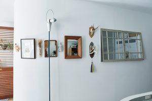 カーブを描く壁には窓を付けて、より開放的に。アンティークの鏡コレクションも。