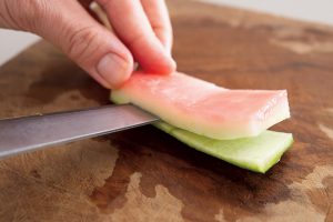 お肉のような独特の食感になるスイカの皮は、緑の硬い部分を取り除いて漬ける。