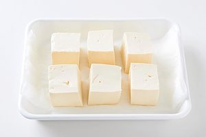 豆腐はペーパータオルにのせ、上からもう一枚ペーパータオルをのせて水気をとる。