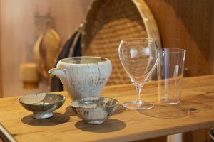 テーブルとしても使えるキッチンの収納棚は、家飲みの定位置。ビールには極薄のガラスのタンブラー、ワインには安定感のある脚の短いハンドメイドグラスを。日本酒には山形県の酒田を旅行したときに見つけた片口とぐい呑を愛用。