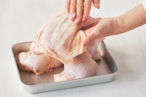 塩をふるとき鶏皮のしわを広げて肉を包み込むよう整えると、形よくゆであがる。