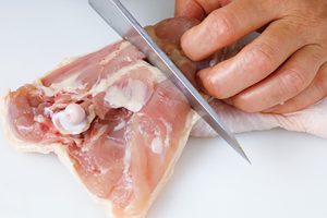 鶏もも肉を3つに切る。関節に包丁を入れると切りやすい。