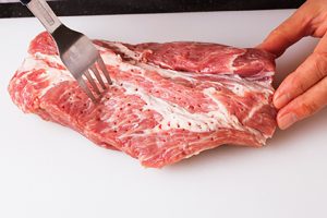 豚肉の全体をフォークでくまなく刺す。血抜きと、味を染みやすくするため。