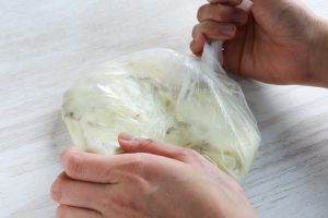 （2）ラップとキッチンペーパーを取ってポリ袋に入れ、塩・こしょうを振り、熱いうちに、袋の外から手で潰す。（やけどに注意してくださいね）