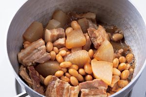 スープに大豆を加え、醤油、みりんで煮る。沸騰したら火を弱め、落とし蓋を。