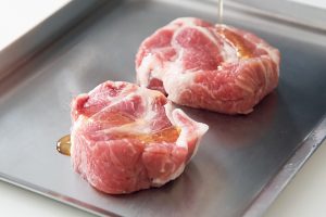 塩豚にごま油をつけて焼くと香ばしくなり、程よく塩が効いた肉の旨みと熟成感を堪能できる。韓国焼き肉風に野菜で包んで。