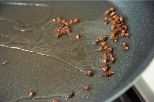 花椒は粒のまま油で炒めると、爽やかな香りと風味が生かされる。香りが立ったら、片栗粉を揉みこんだ塩豚を入れて焼く。