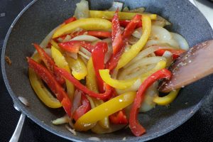 （3）フライパンにオリーブオイル、にんにくを入れて弱火で熱し、にんにくの香りが出てきたら、玉ねぎ、パプリカを炒める。