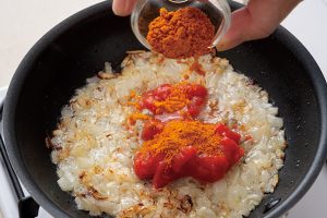 5.トマト水煮缶と基本のミックススパイスを加え、強火で30秒炒める。