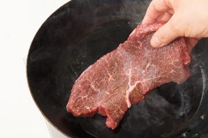 2.フライパンにサラダ油（牛脂でも可）を中強火で熱し、薄煙が出たら牛肉を入れる。