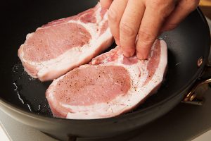 2.フライパンを中火にかけ油を熱し、豚肉を盛りつける面を下にして入れてフタをし、こんがりと色づくまで2分ほど焼く。