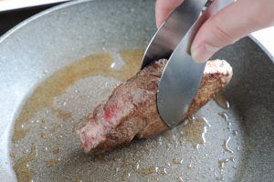 （4）同じフライパンにオリーブオイルを熱し、牛肉を強めの中火で、焼き色がつくまで焼く。アルミホイルで包み5分ほど置き、薄くスライスする。