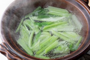 小松菜は茎の部分だけ先に鍋に入れ、少し煮る。