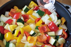 野菜を炒め合わせ、玉ねぎが透き通ってきたら、塩を加える。