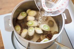 ごぼうと煮干しのオイル煮、長ねぎを鍋で軽く炒め、水を加える。