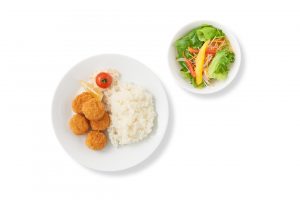 「新生活応援　ワンコインセット　プラントベース唐揚げプレート サラダ付き」（500円）ワンコイン500円で食べられる、まるで鶏の唐揚げのような食感・風味のプラントベース唐揚げとライス、サラダのお得なセット。