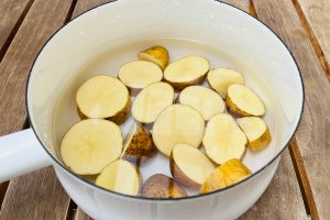 1.玉ねぎはごく薄切りにして塩で揉んで水にさらして辛味を除き、りんごはいちょう切りにして塩水につけておきます。鍋にざく切りにしたジャガイモとかぶるくらいの水を入れ火にかけ、ジャガイモに火を通します。