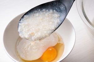 加熱したての熱いオートミールを器に割っておいた卵に注ぐと、余熱で半熟卵に。