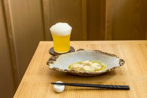 おまかせコースのこの日の1stディッシュは北海道産ホタテのカルパッチョ。ペアリングはシャンパンベースに日本酒とキウイ、洋梨、ユズが香るフルーティーなカクテル。