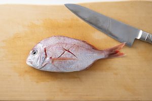 うろこと内臓を取った魚の、表側の皮面に切り込みを入れる。