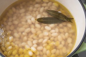 5.3の豆が八分通りやわらかくなったら、香味野菜（玉ねぎ、人参、セロリ）を引き上げ、ブイヨンを豆の上2cmくらいまで加える。さらにキャベツを入れて煮る。