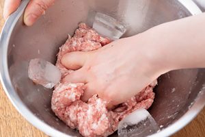 1.肉が温まるとパサつく原因に。氷を入れて低温を保ち、練る。