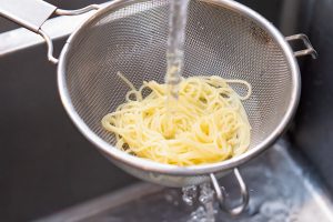 2.茹でてザルに上げたパスタを流水にさらし、粗熱を取る。