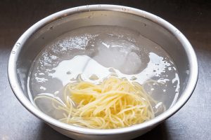 3.パスタを氷水に浸けて、10〜20秒しっかり冷やし、ザルに上げる。